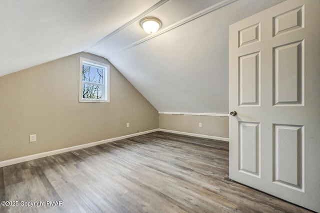 additional living space featuring wood-type flooring and vaulted ceiling