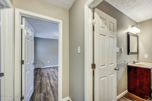 bathroom featuring vanity, hardwood / wood-style floors, and a textured ceiling