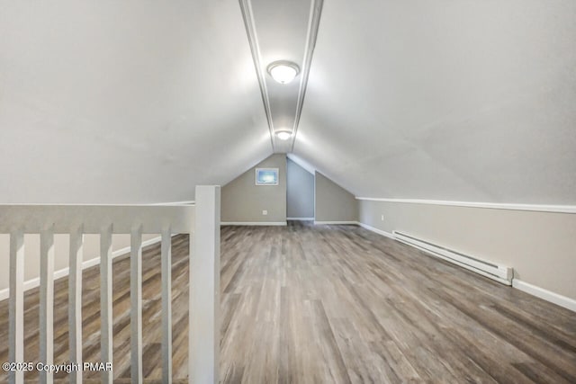 additional living space featuring hardwood / wood-style flooring, lofted ceiling, and a baseboard heating unit