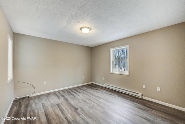 unfurnished room with a baseboard radiator, a textured ceiling, baseboards, and wood finished floors