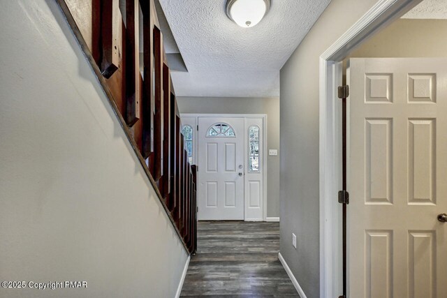 entrance foyer with dark hardwood / wood-style floors and a textured ceiling