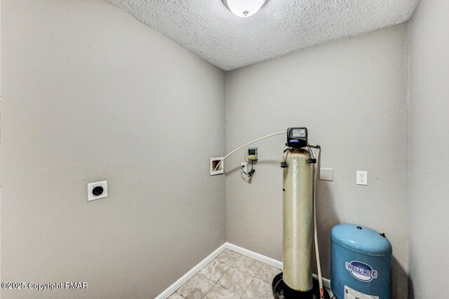 clothes washing area with electric dryer hookup, hookup for a washing machine, and a textured ceiling