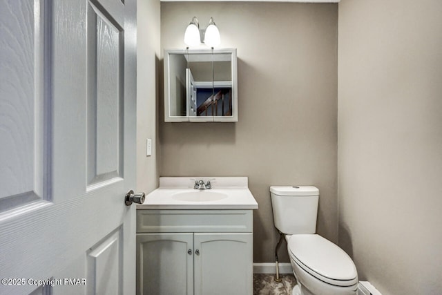 bathroom with vanity, toilet, and baseboards