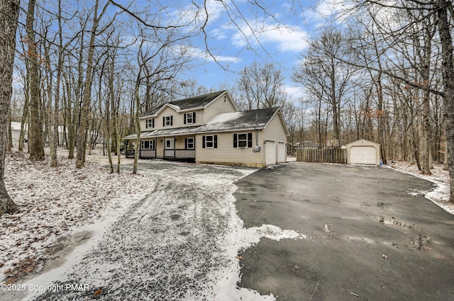 view of front of property featuring a garage, covered porch, and an outdoor structure