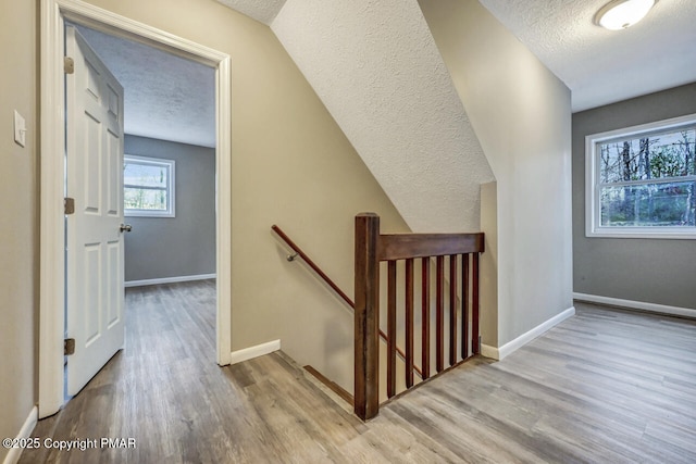 stairway featuring wood-type flooring and a textured ceiling