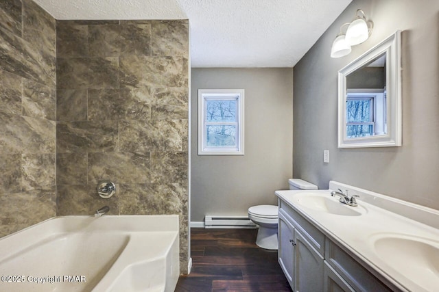 full bathroom featuring vanity, a baseboard heating unit, wood-type flooring, and a textured ceiling