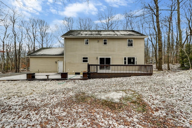 snow covered rear of property with a wooden deck