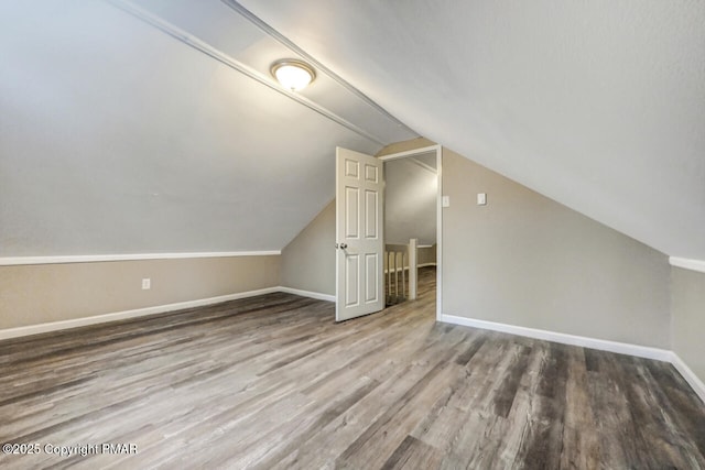 additional living space with lofted ceiling, baseboards, and wood finished floors