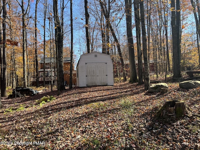 view of yard featuring a storage shed and an outbuilding