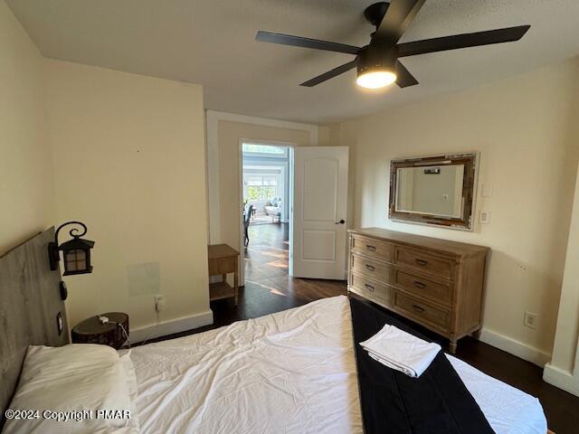 bedroom featuring ceiling fan, dark wood finished floors, and baseboards