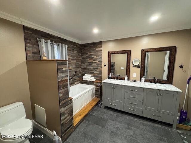 bathroom with ornamental molding, double vanity, toilet, and a bath