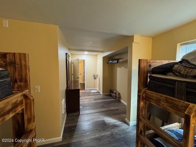 hallway featuring dark wood-style flooring and baseboards