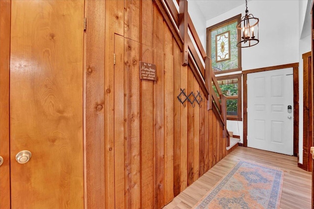 99 Ruffed Grouse Ct, Lake Harmony, PA 18624 - foyer entrance with a chandelier, wood walls, wood finished floors, and stairway