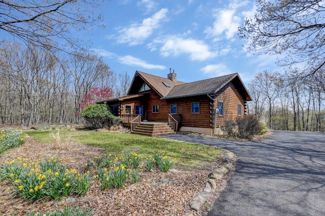 14 E Point Rd, Albrightsville, PA 18210 - view of side of home featuring a chimney, a shingled roof, driveway, log siding, and covered porch