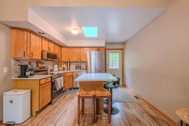 133 Sundew Dr, East Stroudsburg, PA 18301 - kitchen featuring stainless steel appliances, light countertops, light wood-style flooring, and a kitchen island