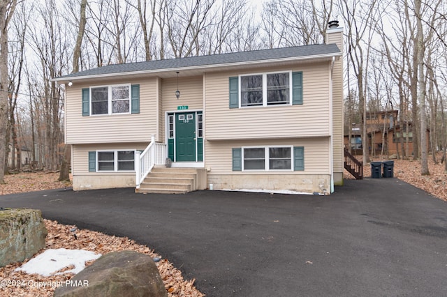 133 Sundew Dr, East Stroudsburg, PA 18301 - raised ranch featuring a chimney, driveway, and entry steps