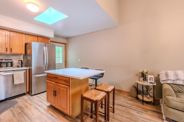 133 Sundew Dr, East Stroudsburg, PA 18301 - kitchen featuring appliances with stainless steel finishes, a skylight, a kitchen bar, light wood-style floors, and light countertops