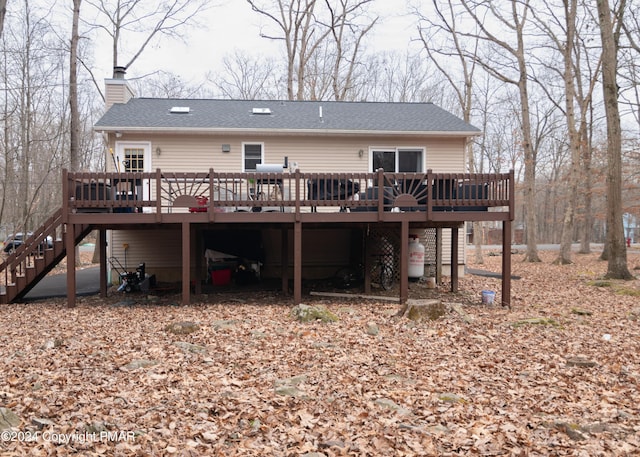 133 Sundew Dr, East Stroudsburg, PA 18301 - rear view of property with a deck, a chimney, stairway, and a shingled roof