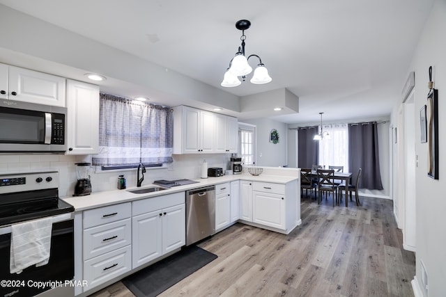 kitchen featuring stainless steel appliances, white cabinets, a sink, and decorative backsplash