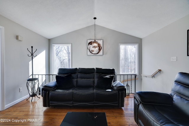 living area featuring lofted ceiling, dark wood finished floors, and baseboards