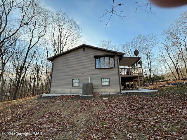 back of property with a deck, a patio, and central air condition unit