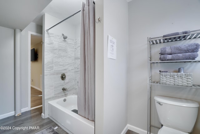 bathroom with shower / tub combo, wood finished floors, toilet, and baseboards