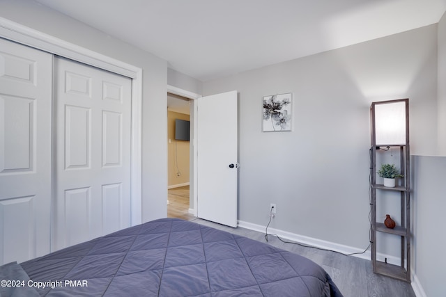 bedroom featuring a closet, baseboards, and wood finished floors