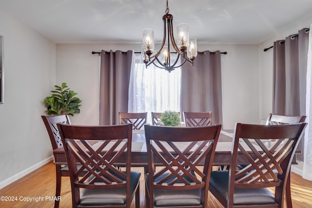 dining space with light wood finished floors, baseboards, and a chandelier