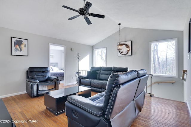 living area featuring lofted ceiling, plenty of natural light, and hardwood / wood-style flooring