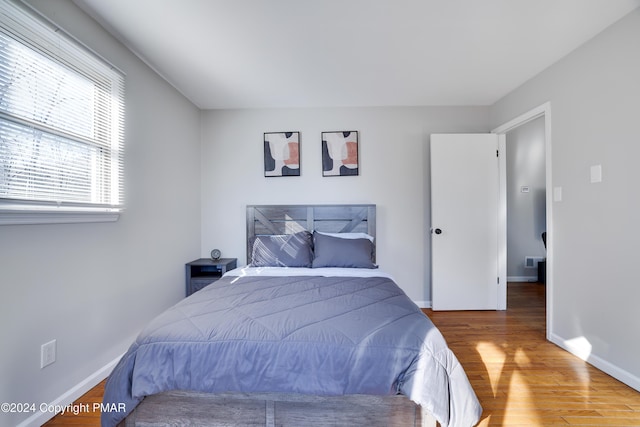 bedroom featuring baseboards and wood finished floors