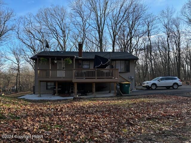 view of front of home featuring a patio area, a chimney, and a deck