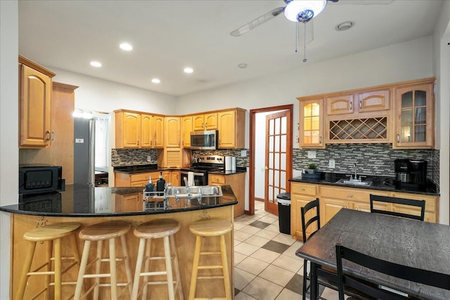 392 Hemlock Dr, Tobyhanna, PA 18466 - kitchen featuring stainless steel appliances, decorative backsplash, a peninsula, glass insert cabinets, and recessed lighting