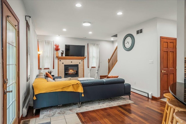 392 Hemlock Dr, Tobyhanna, PA 18466 - living room featuring a baseboard radiator, a tiled fireplace, stairway, recessed lighting, and wood finished floors