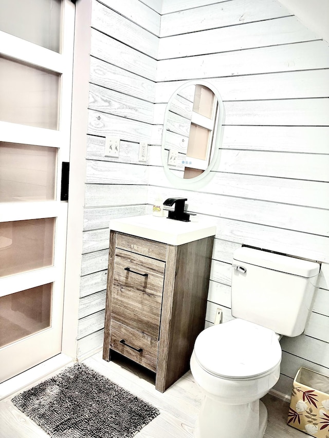 256 Partridge Dr, Pocono Lake, PA 18347 - half bathroom with vanity, wood walls, toilet, and wood finished floors