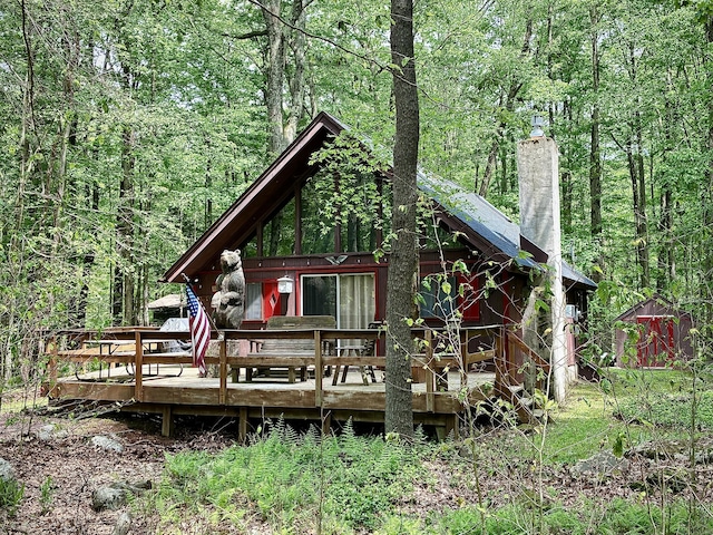 256 Partridge Dr, Pocono Lake, PA 18347 - view of front of property featuring a chimney, a wooded view, and a deck