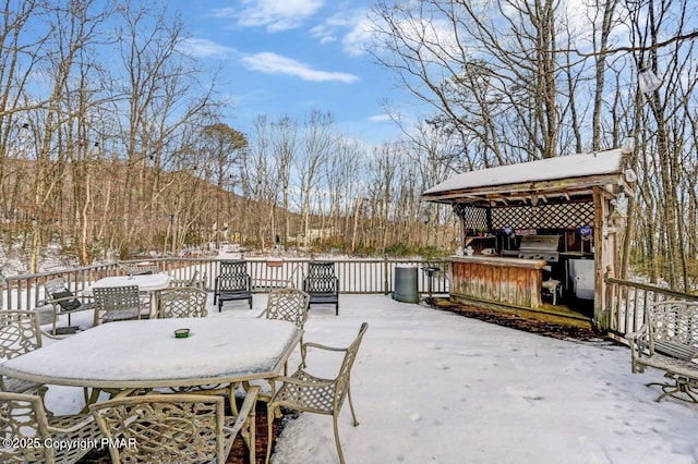 snow covered deck with a mountain view and an outdoor bar