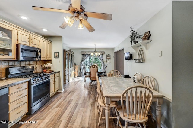 kitchen featuring stainless steel appliances, decorative light fixtures, light hardwood / wood-style floors, tasteful backsplash, and ceiling fan with notable chandelier