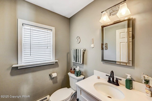 bathroom featuring toilet, a baseboard heating unit, and vanity