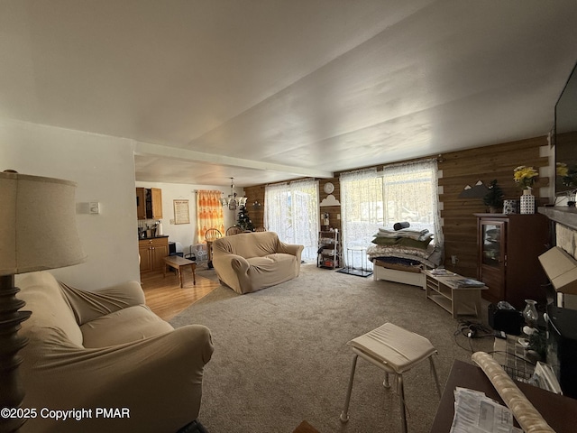 carpeted living room with wood walls and a notable chandelier