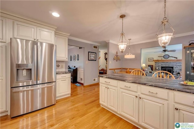 536 Mcilhaney Rd, Stroudsburg, PA 18360 - kitchen with stainless steel fridge, a fireplace, crown molding, light wood finished floors, and hanging light fixtures