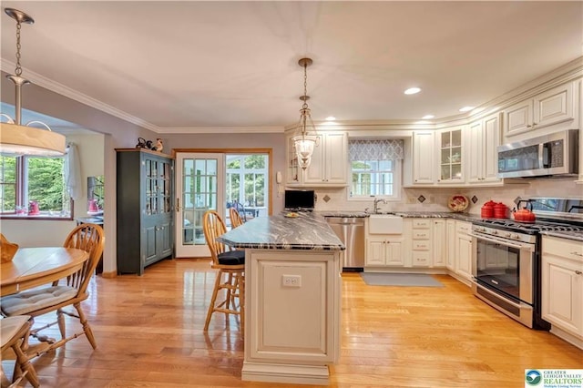 536 Mcilhaney Rd, Stroudsburg, PA 18360 - kitchen featuring appliances with stainless steel finishes, a kitchen breakfast bar, a peninsula, glass insert cabinets, and ornamental molding