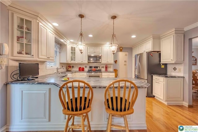 536 Mcilhaney Rd, Stroudsburg, PA 18360 - kitchen with stainless steel appliances, a peninsula, decorative backsplash, glass insert cabinets, and light wood finished floors