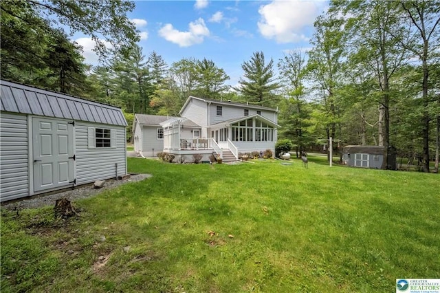 536 Mcilhaney Rd, Stroudsburg, PA 18360 - rear view of property with a storage unit, a sunroom, a yard, and view of wooded area