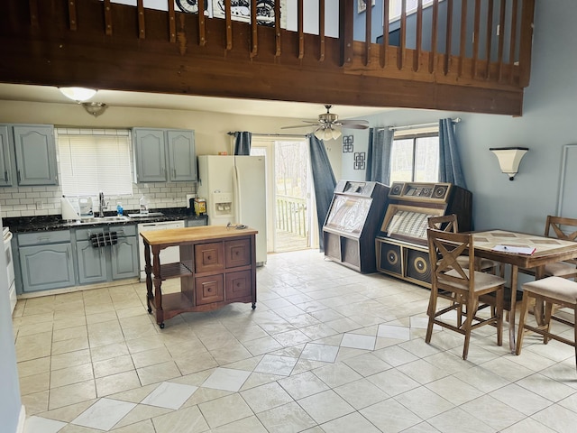 kitchen featuring a sink, white appliances, a ceiling fan, decorative backsplash, and gray cabinetry