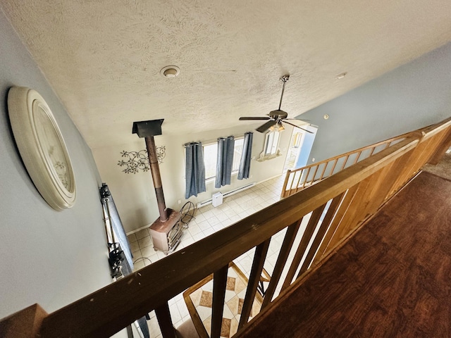 stairs with a ceiling fan, a textured ceiling, and tile patterned floors