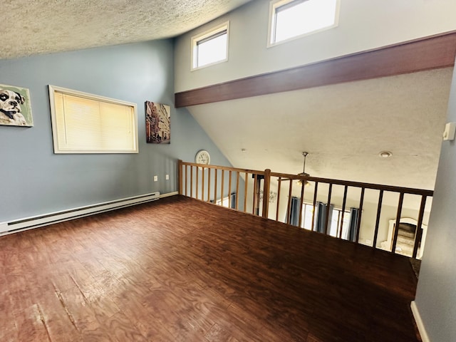 additional living space with a textured ceiling, high vaulted ceiling, wood finished floors, and a baseboard radiator
