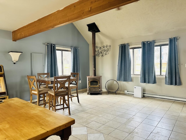 dining space with vaulted ceiling with beams, a wood stove, plenty of natural light, and light tile patterned floors