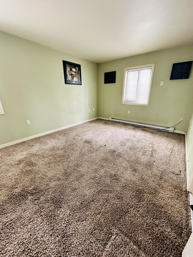spare room featuring baseboards, a baseboard radiator, and carpet