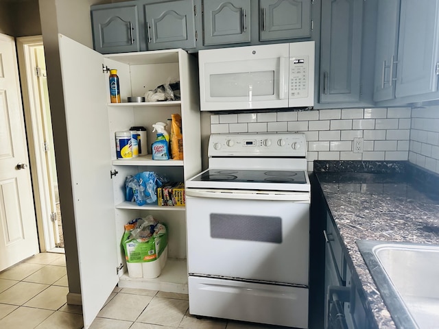 kitchen featuring decorative backsplash, open shelves, light tile patterned floors, a sink, and white appliances