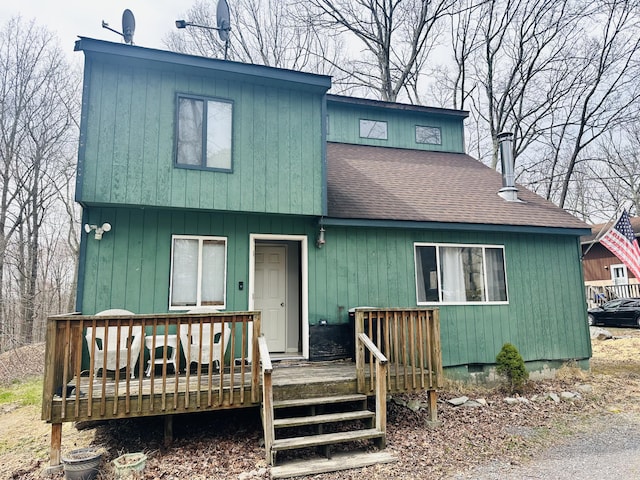 view of front of home featuring roof with shingles and a wooden deck
